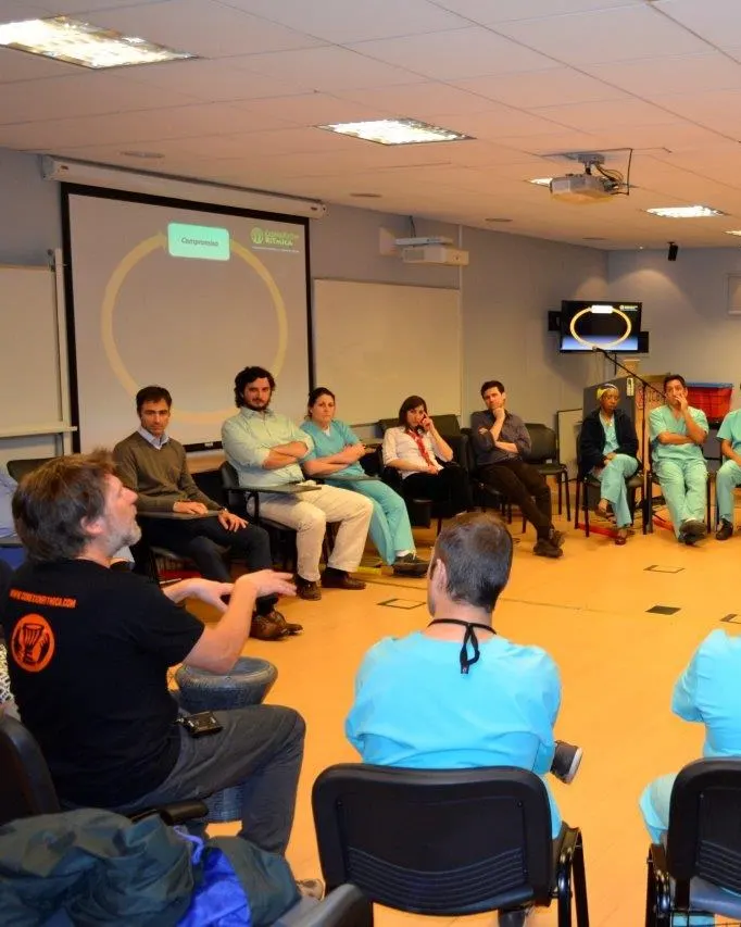 Equipo de salud reunido en círculo con Marcos Ribas en una sala de la clínica.