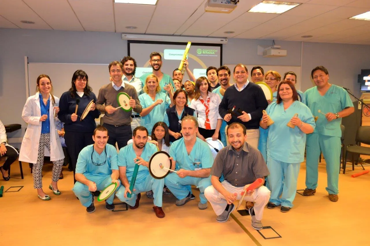Equipo de salud posando sonriente con tambores de marco al terminar una experiencia de conexión.